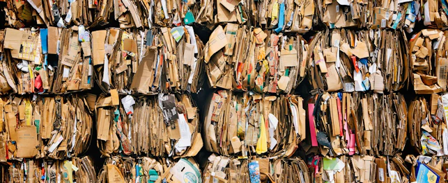 Stosy zużytych kartonowych opakowań przygotowanych do recyklingu.